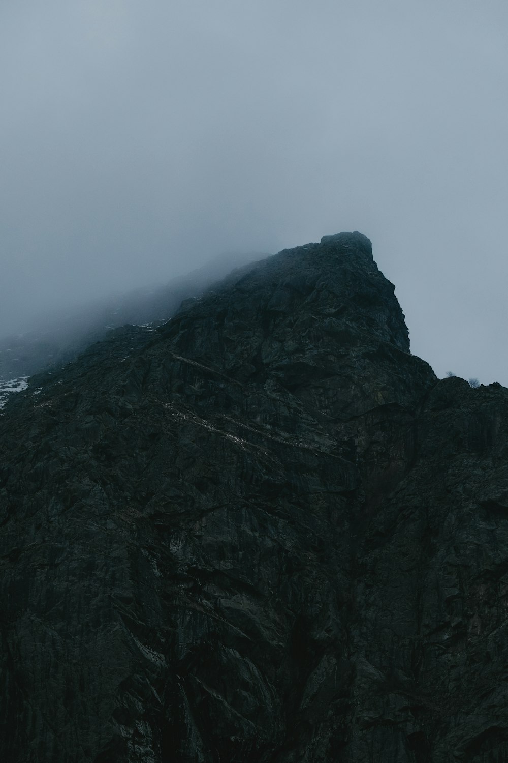 a very tall mountain covered in fog and clouds