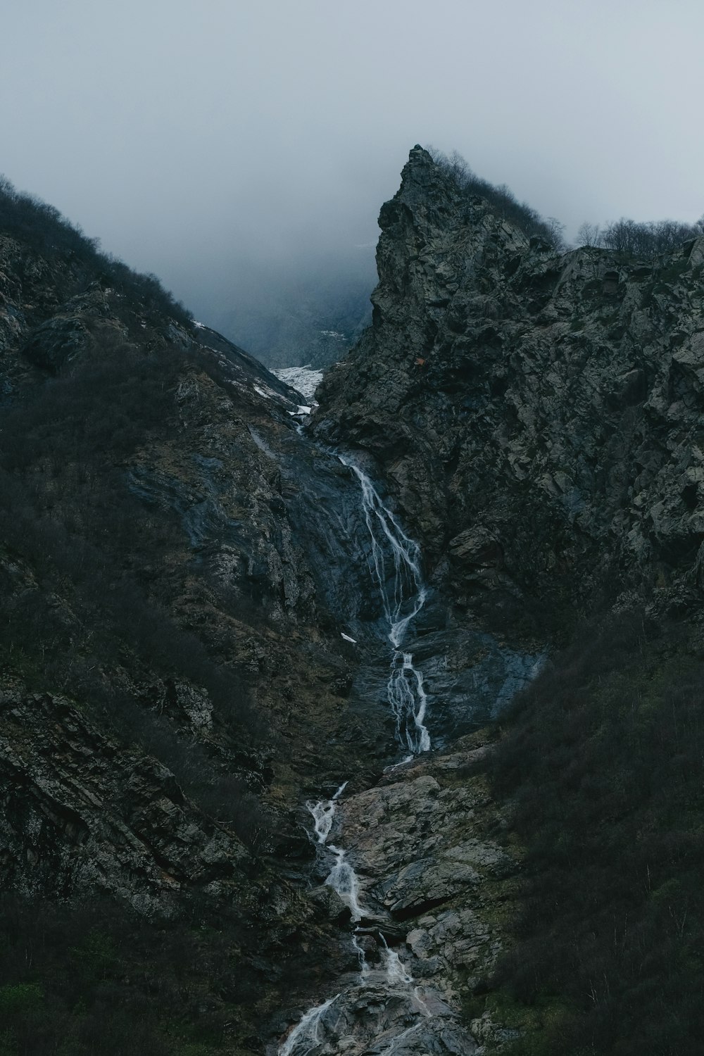 a waterfall in the middle of a mountain
