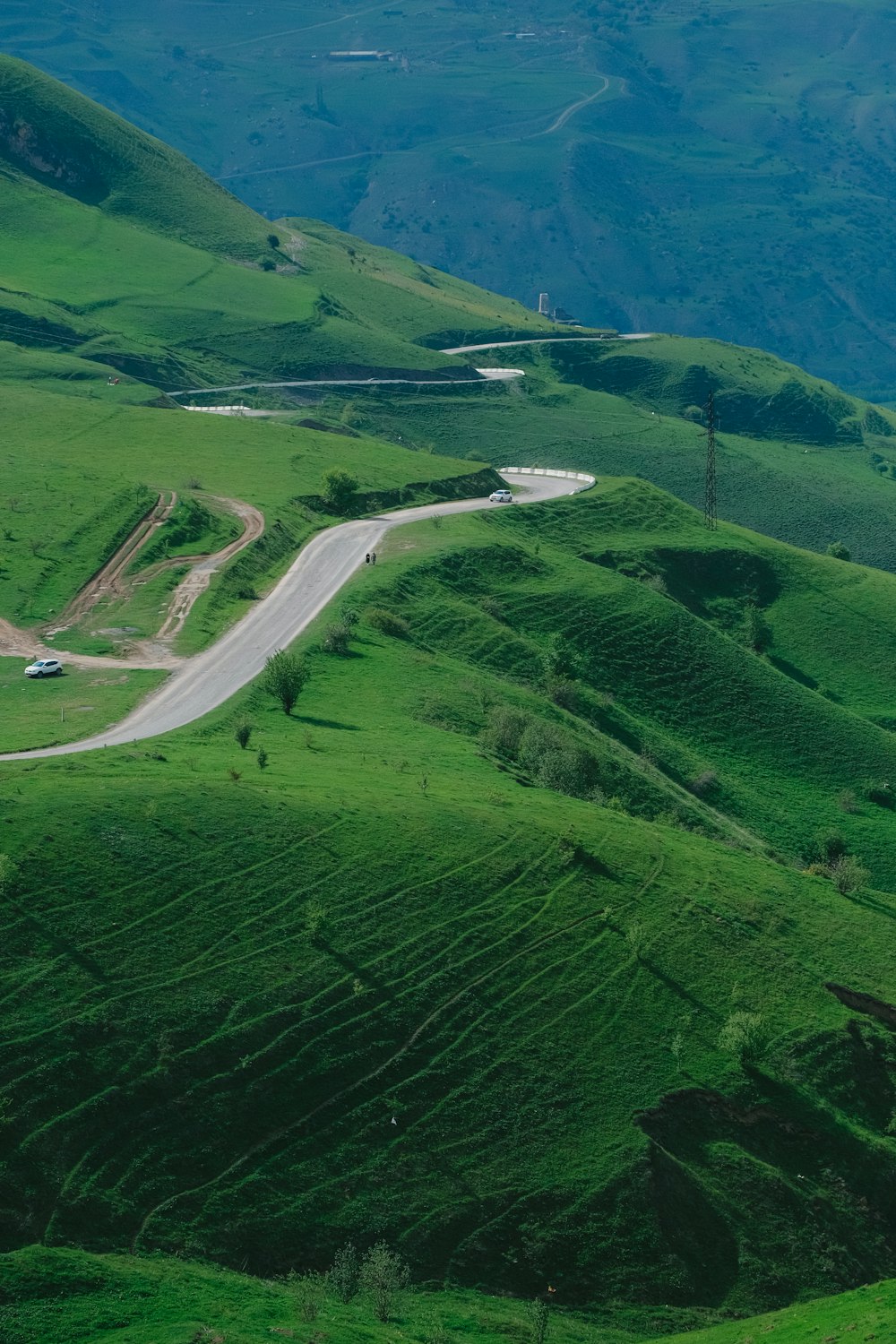 a winding road in the middle of a lush green valley