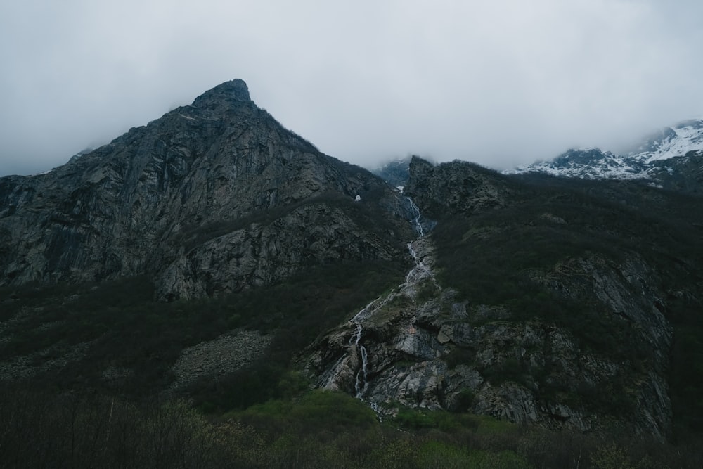 a very tall mountain with a small stream running between it