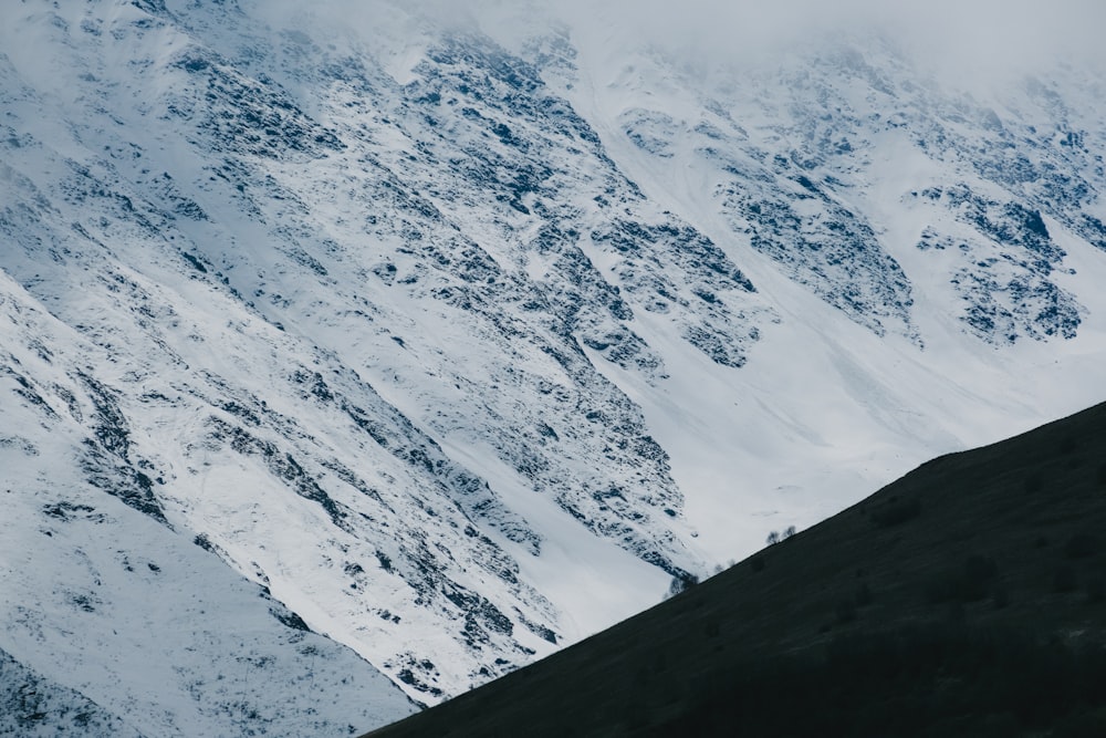 a mountain covered in snow with a sky background