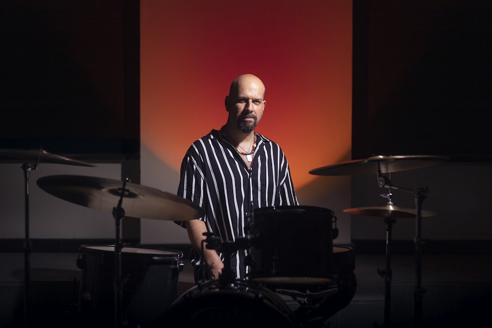 a man is playing drums in a dark room