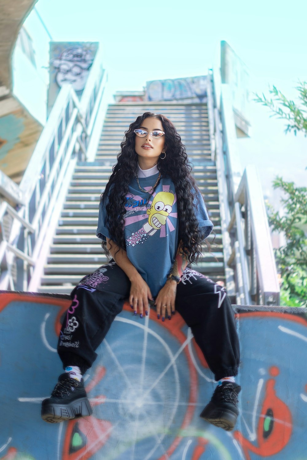 a woman sitting on top of a skateboard ramp