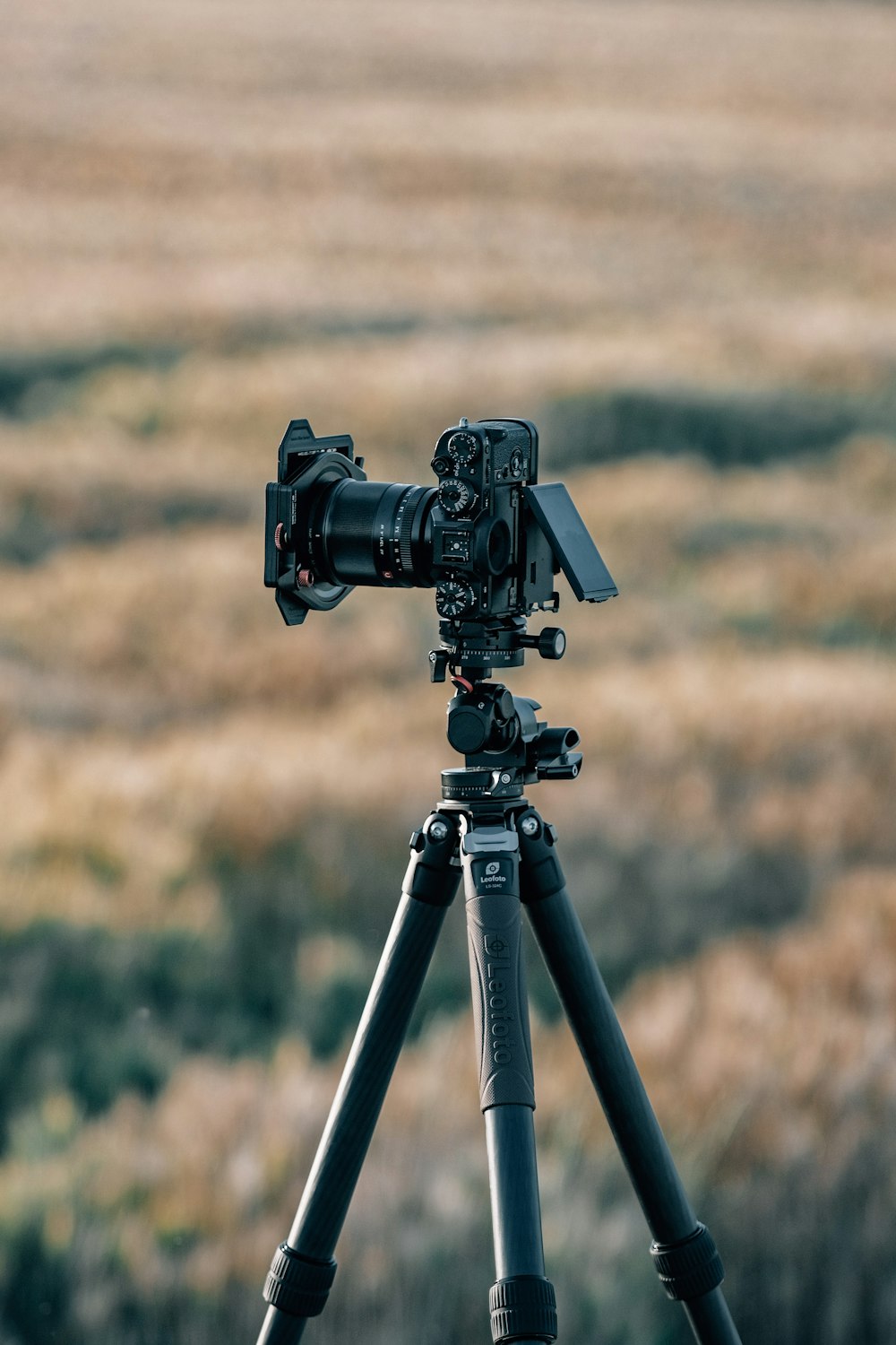 a camera on a tripod in front of a field