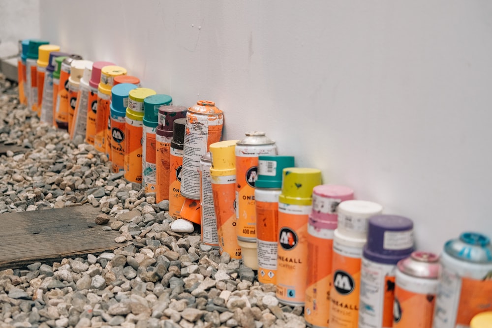 a row of spray paint cans lined up against a wall