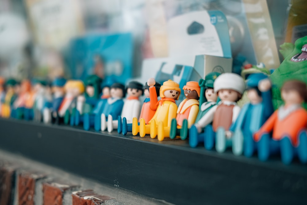 um grupo de estatuetas de brinquedo sentadas em cima de uma prateleira
