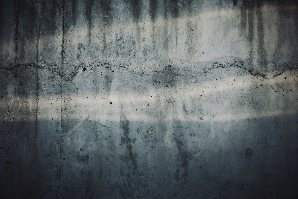 a grungy concrete wall with a light reflecting off of it