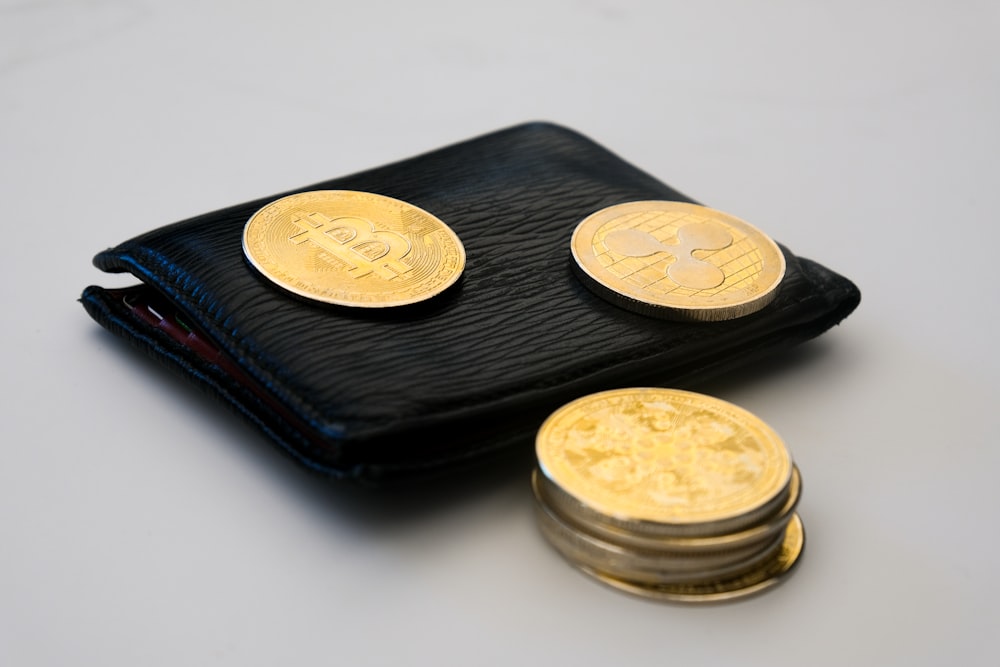 a wallet with three gold coins sitting on top of it