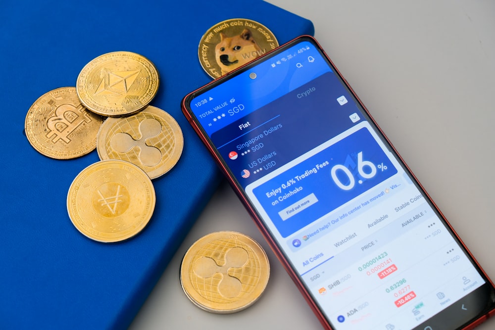 a cell phone sitting next to a pile of coins