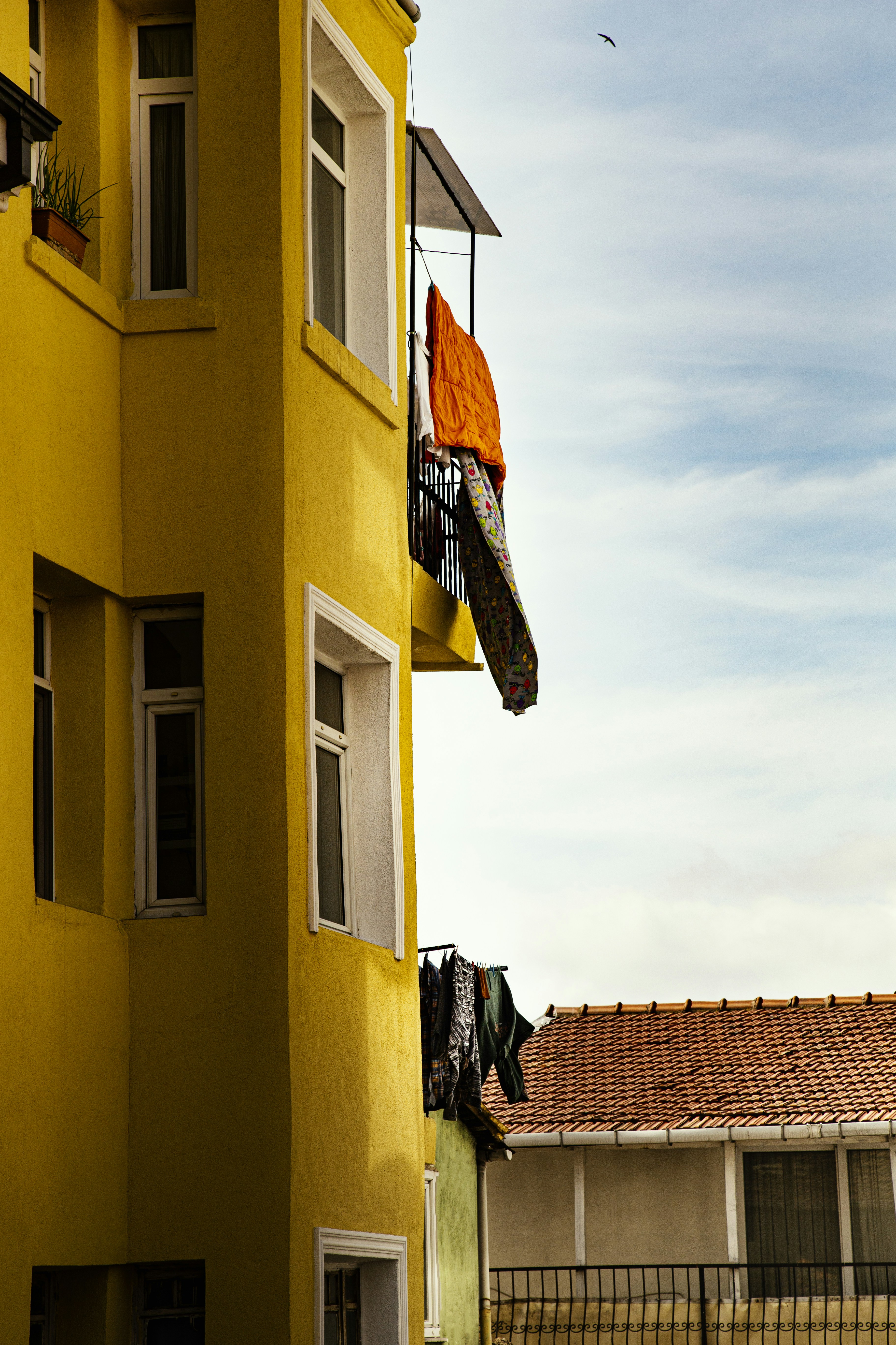 a tall yellow building with a clock on the side of it