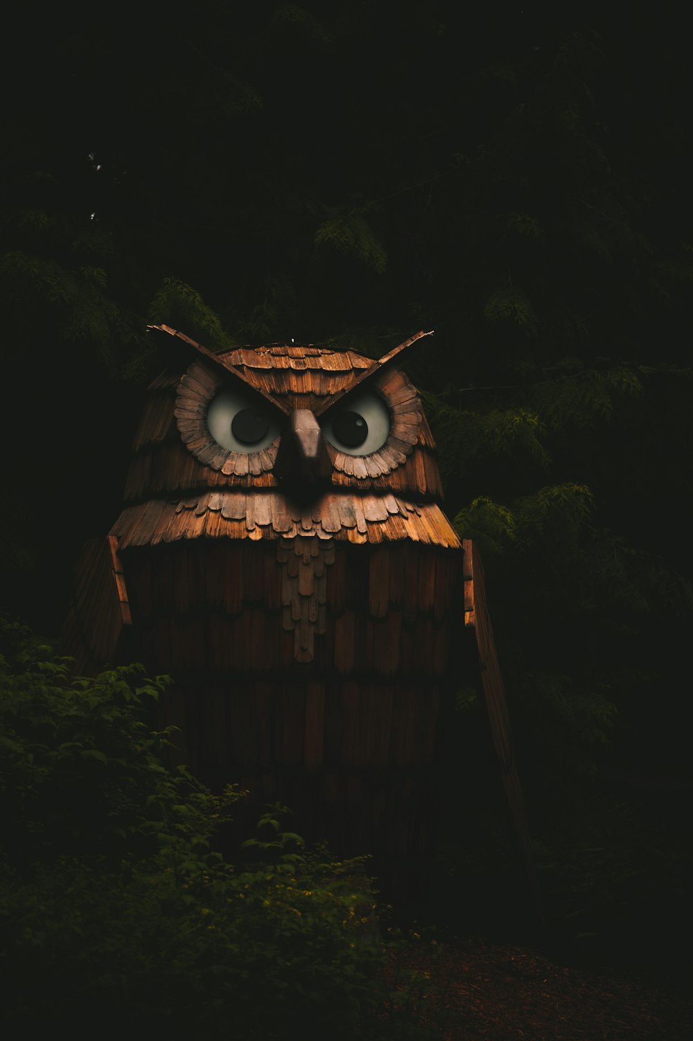 an owl statue is lit up in the dark