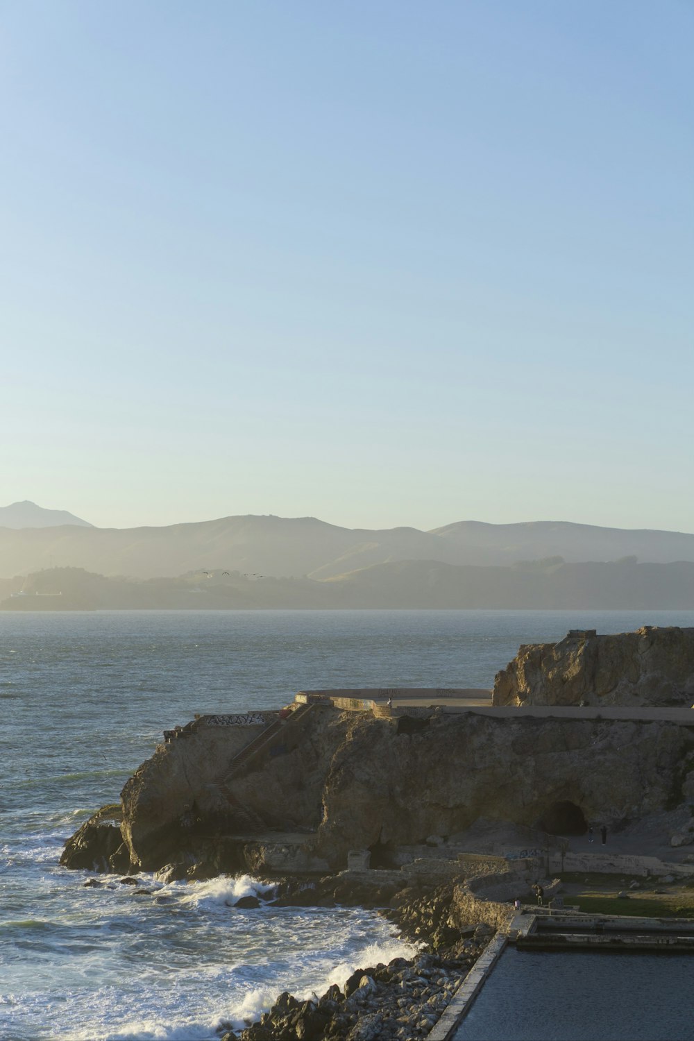 a large body of water sitting next to a rocky shore