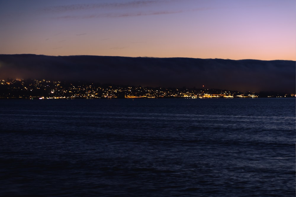 a large body of water with a city in the background