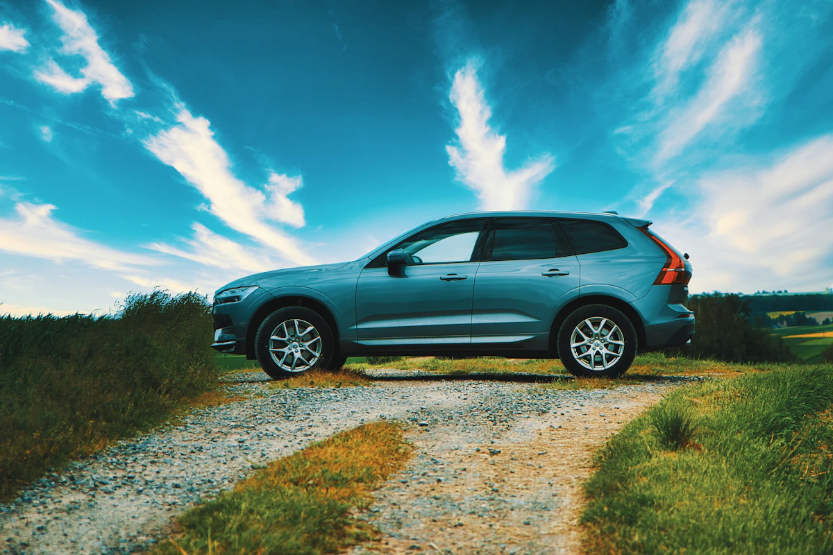 Niebieskie Volvo XC60 zaparkowane na szutrowej drodze