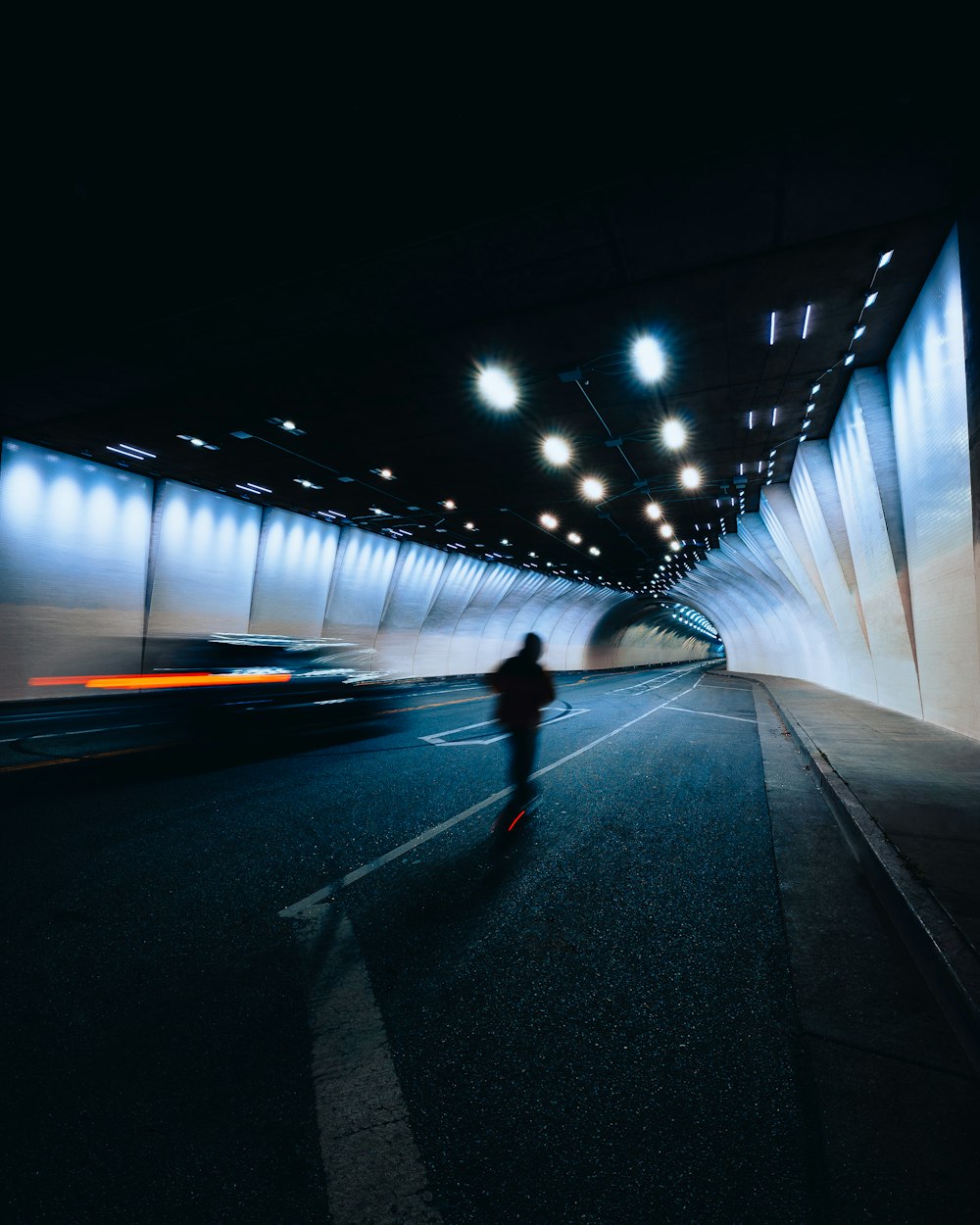 una persona montando un monopatín en un túnel