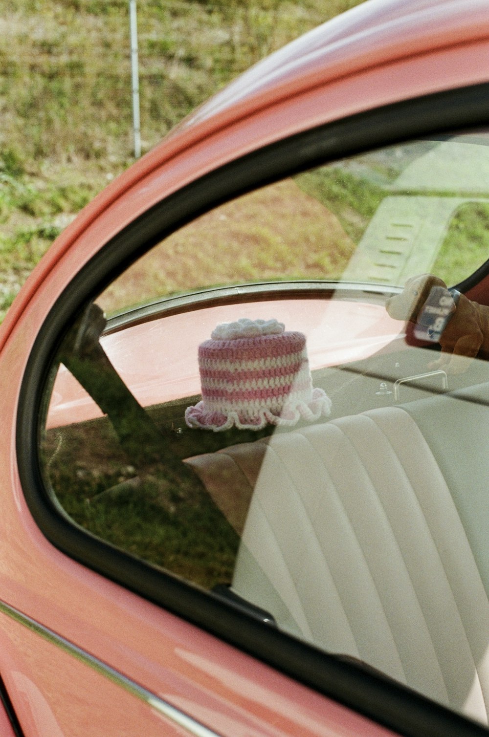 a pink car with a pink and white hat on top of it