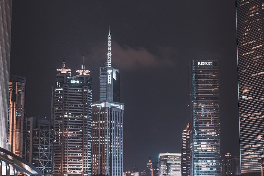 a city skyline at night with skyscrapers lit up