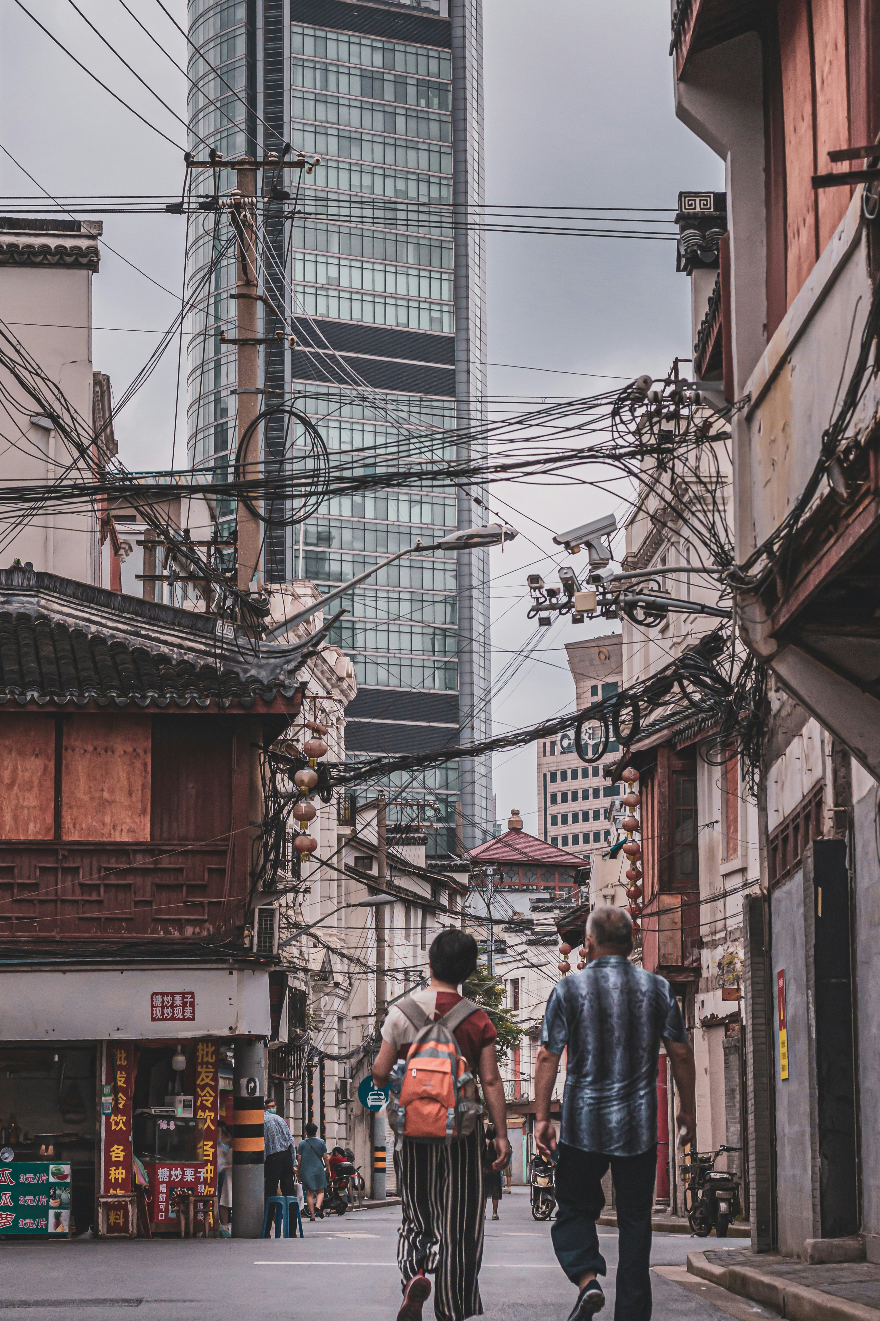 a group of people walking down a street next to tall buildings