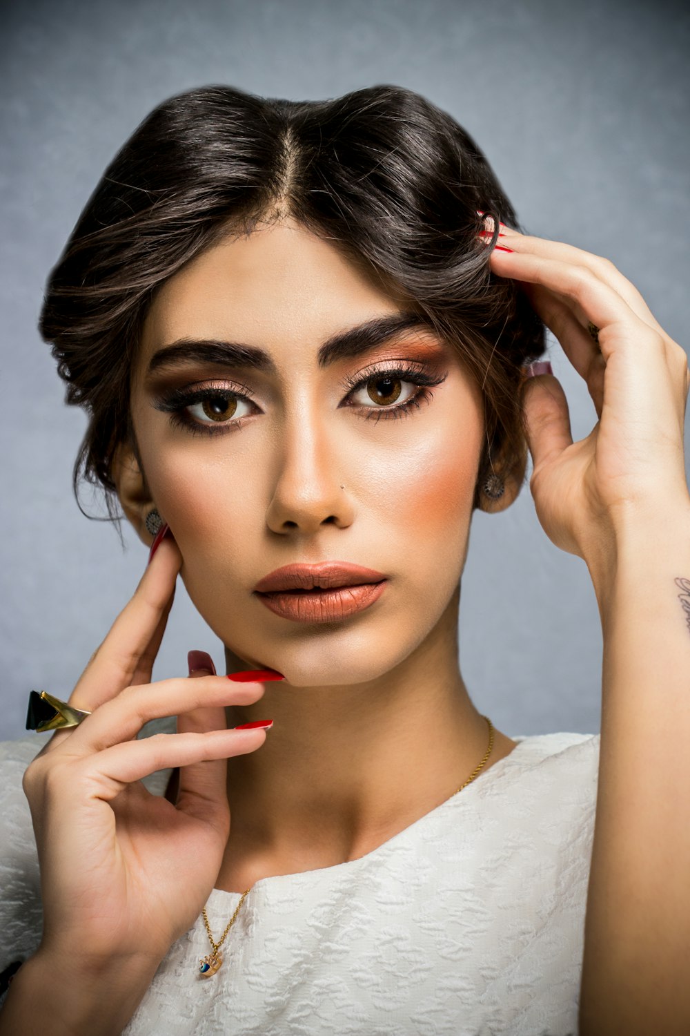 a woman with dark makeup and red nails