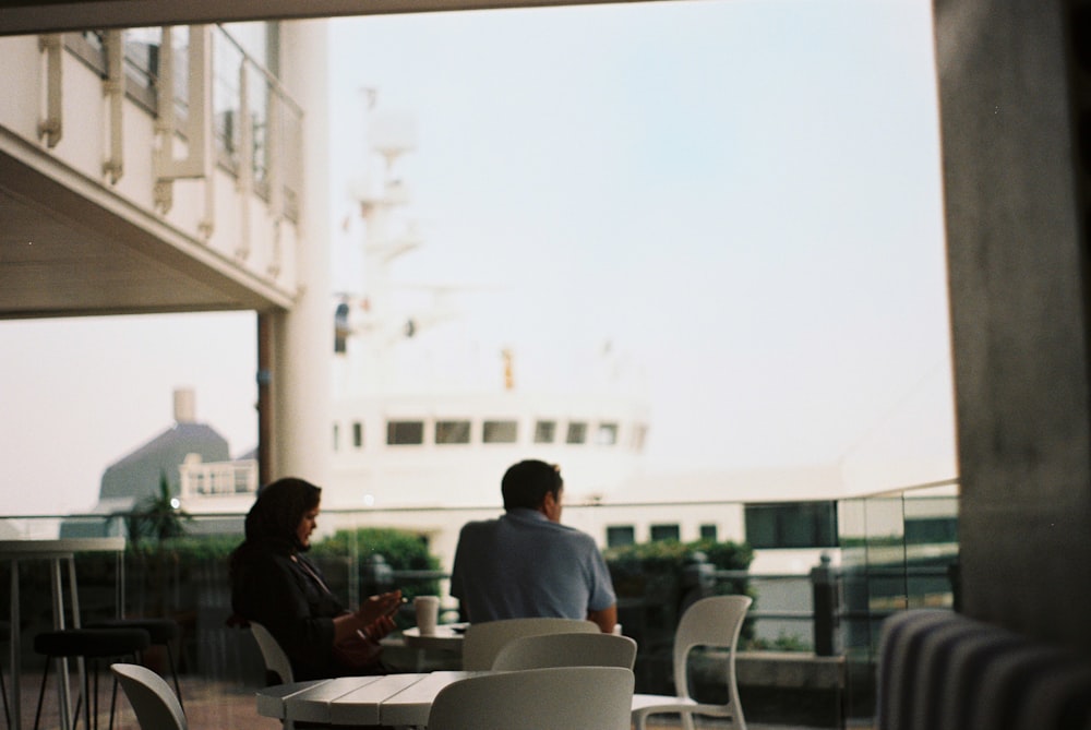 a man and a woman sitting at a table outside