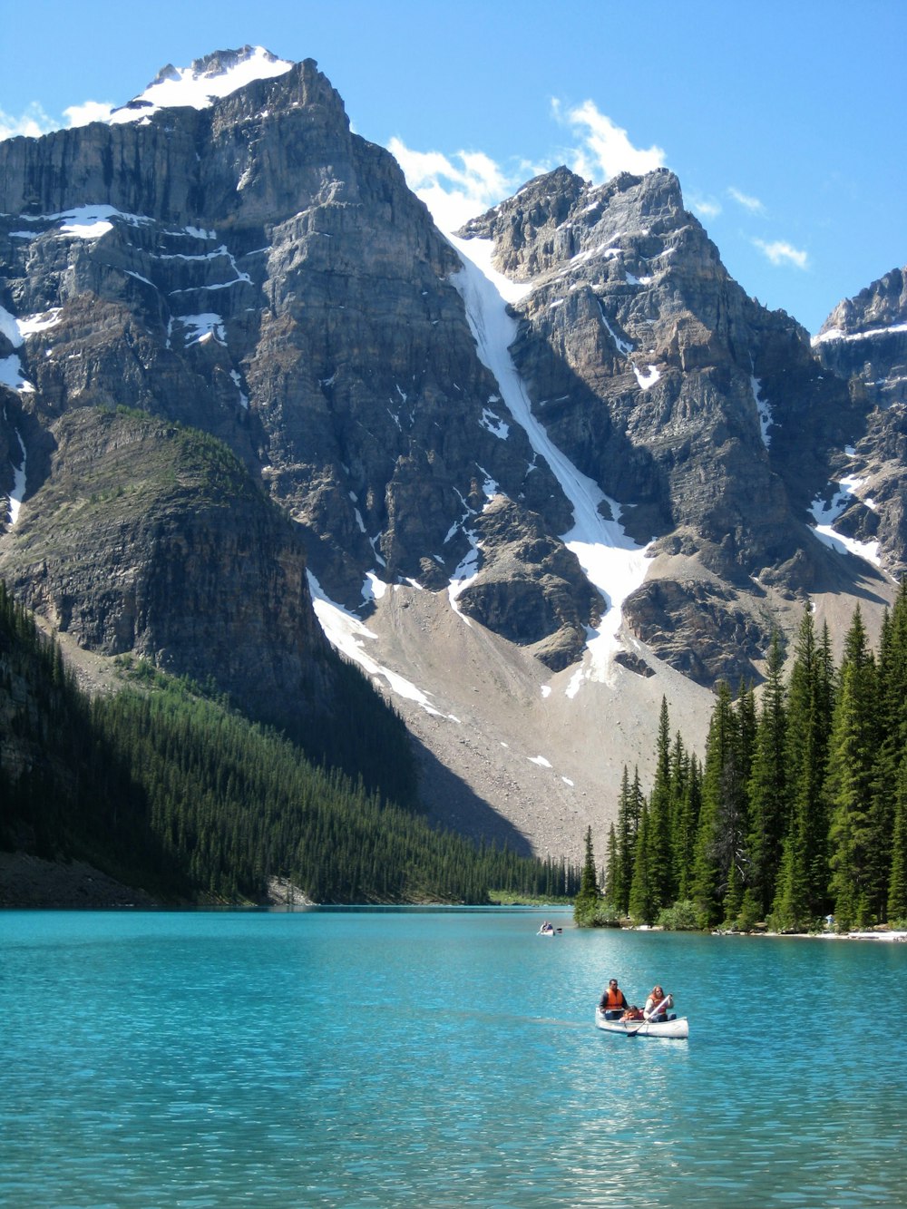 two people in a small boat on a mountain lake