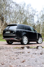 Black Range Rover parked on a gravel drive
