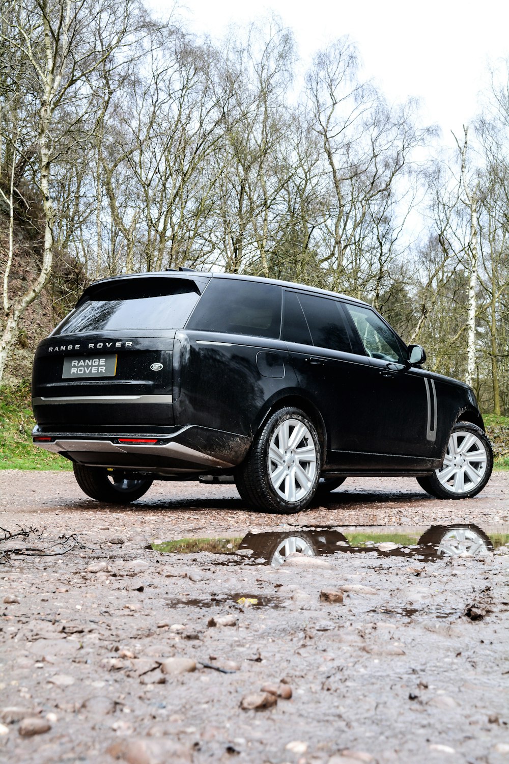 a black range rover parked on a gravel road