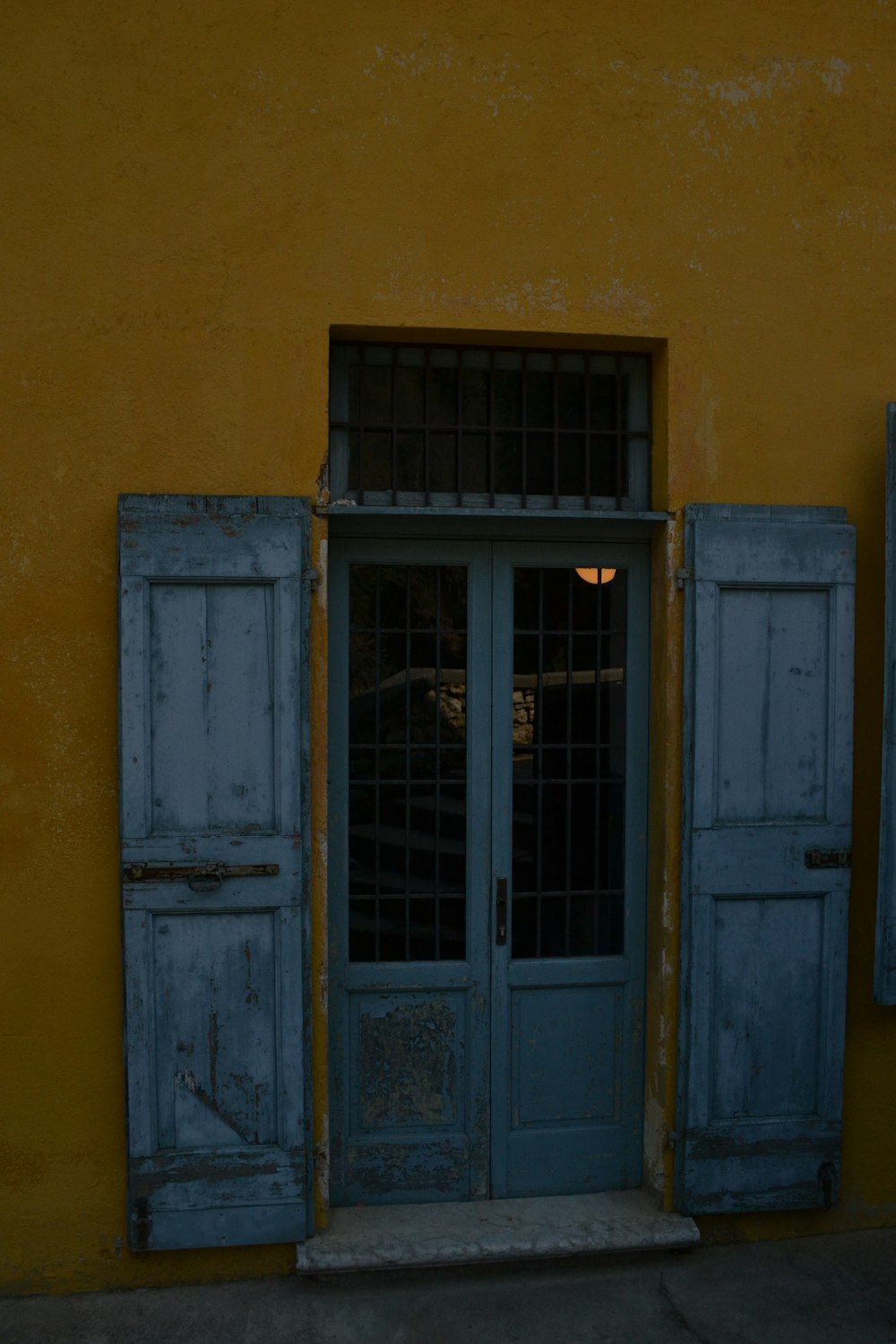 a yellow building with a blue door and window