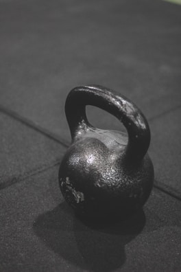 Close-up of a sleek, heavy-duty kettlebell with a matte black finish.