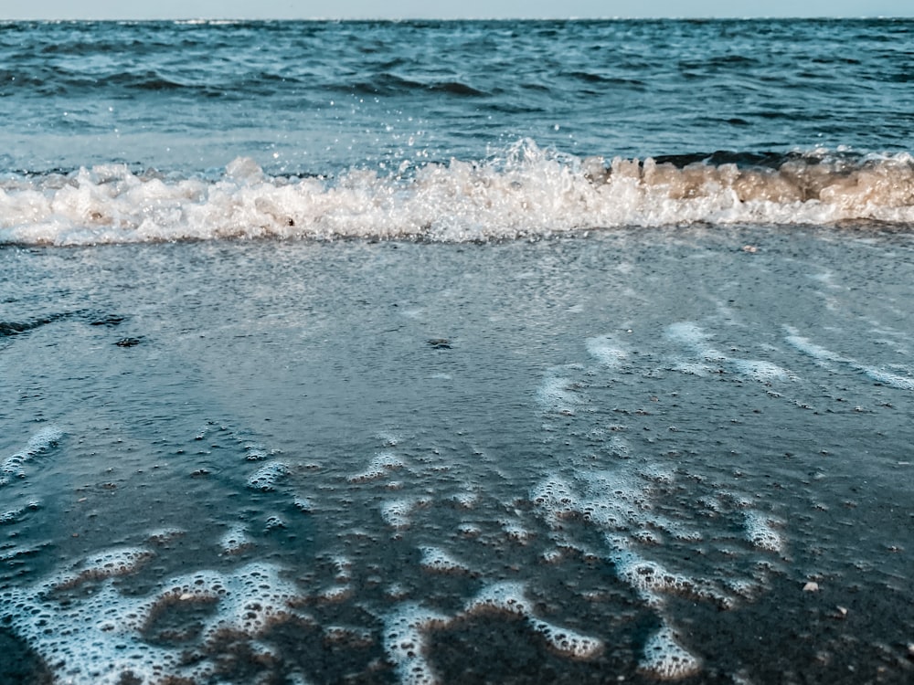 a beach with a wave coming in to shore