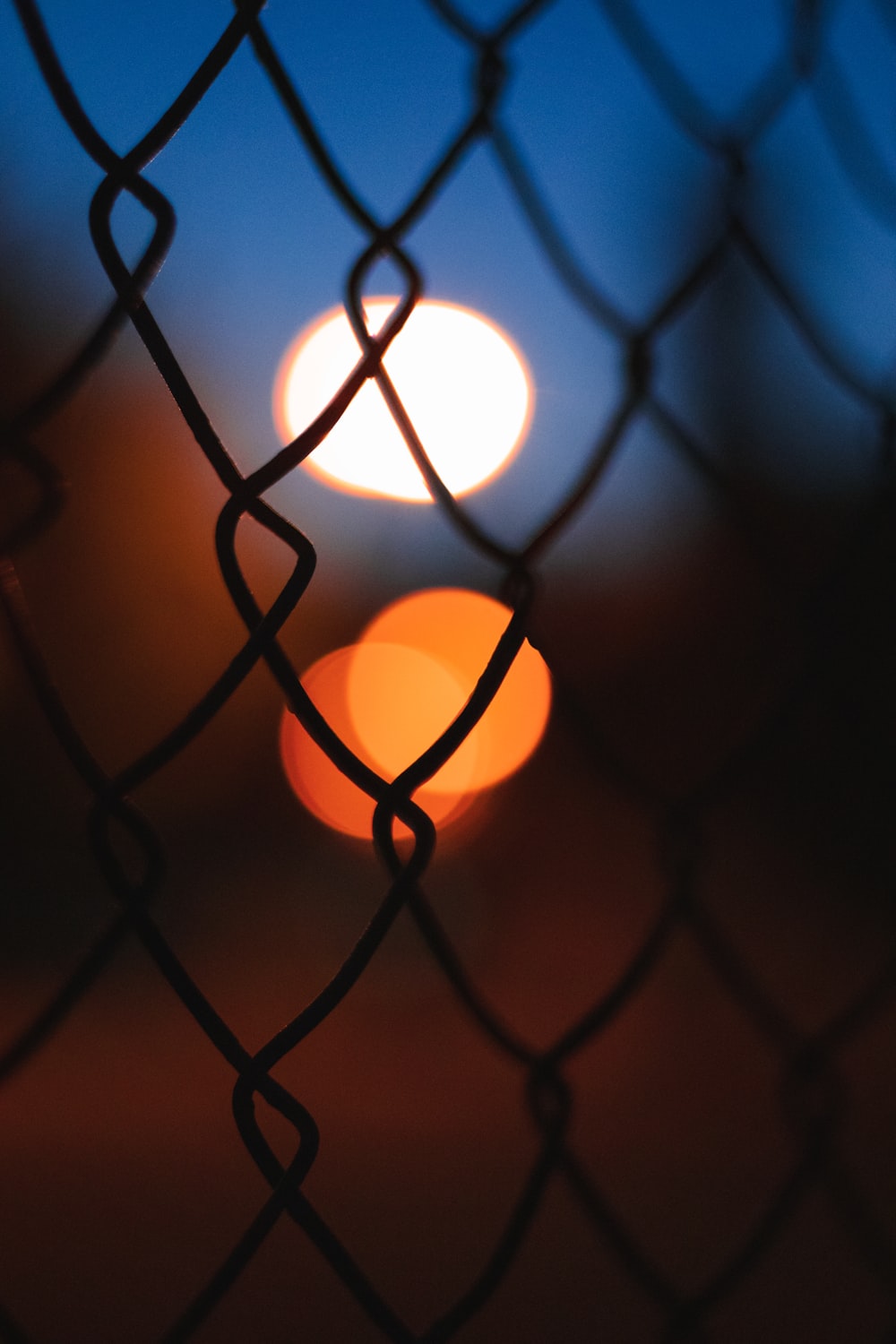 a blurry photo of a street light behind a fence