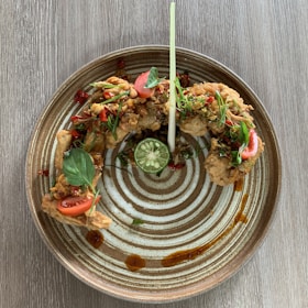 Golden crispy chicken tikka pieces arranged on a rustic wooden platter.