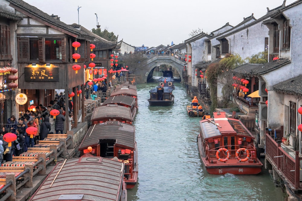 a canal filled with lots of boats next to buildings