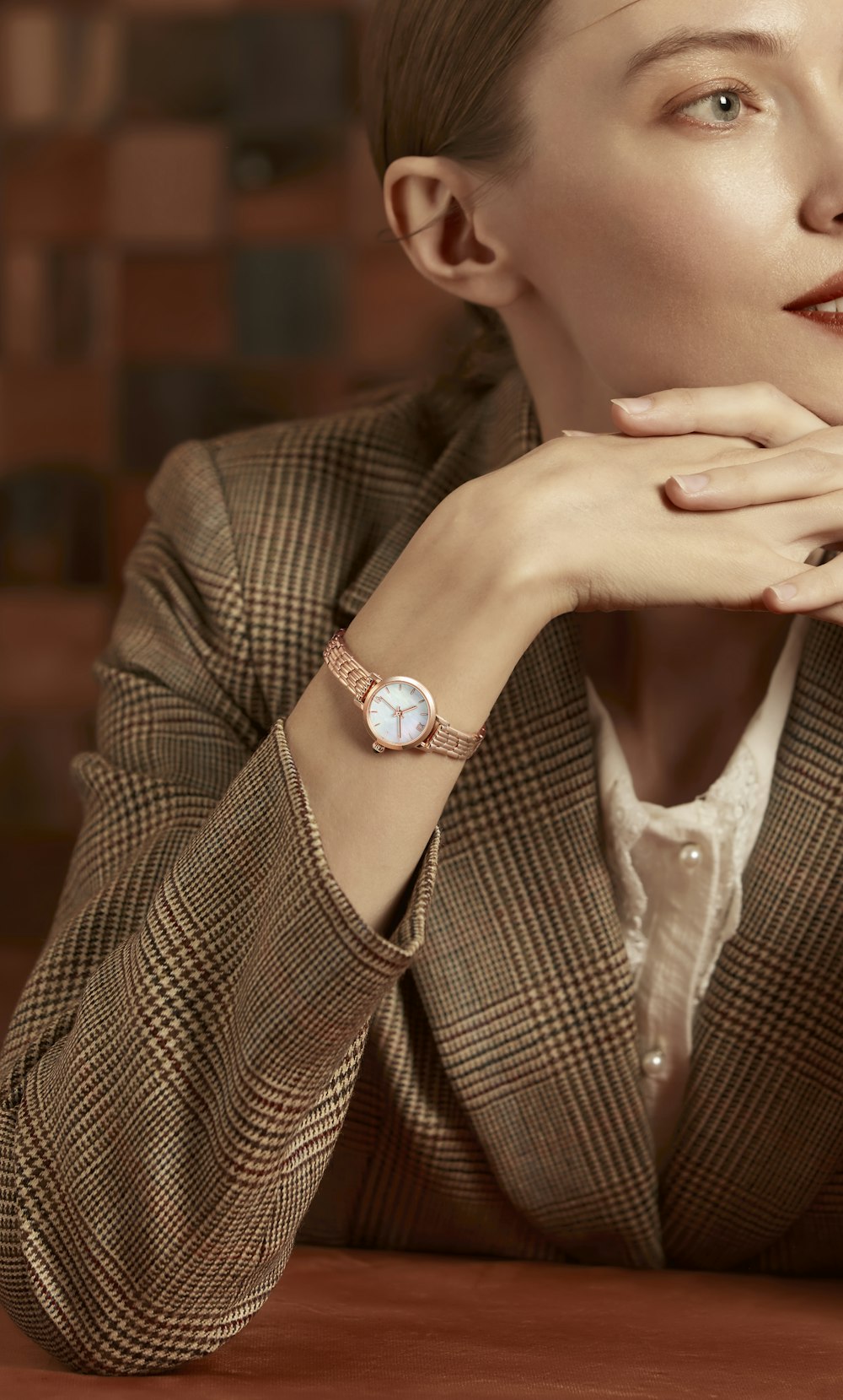 a woman sitting at a table with a watch on her wrist