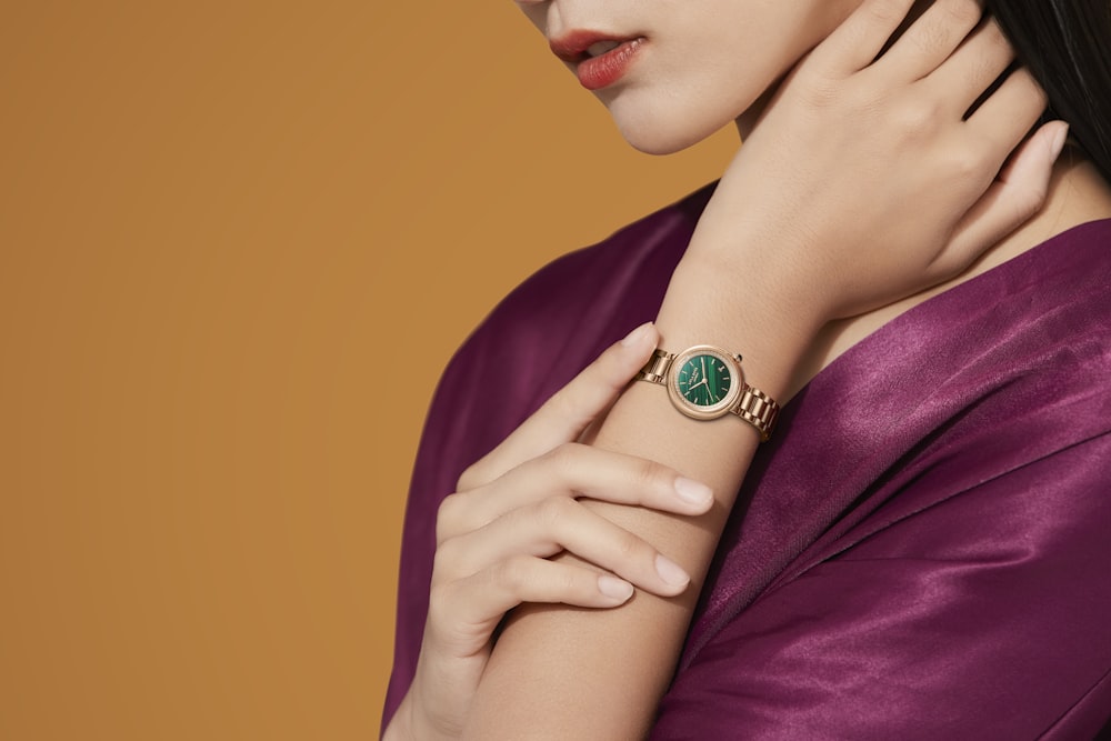 a woman wearing a ring with a green stone on it