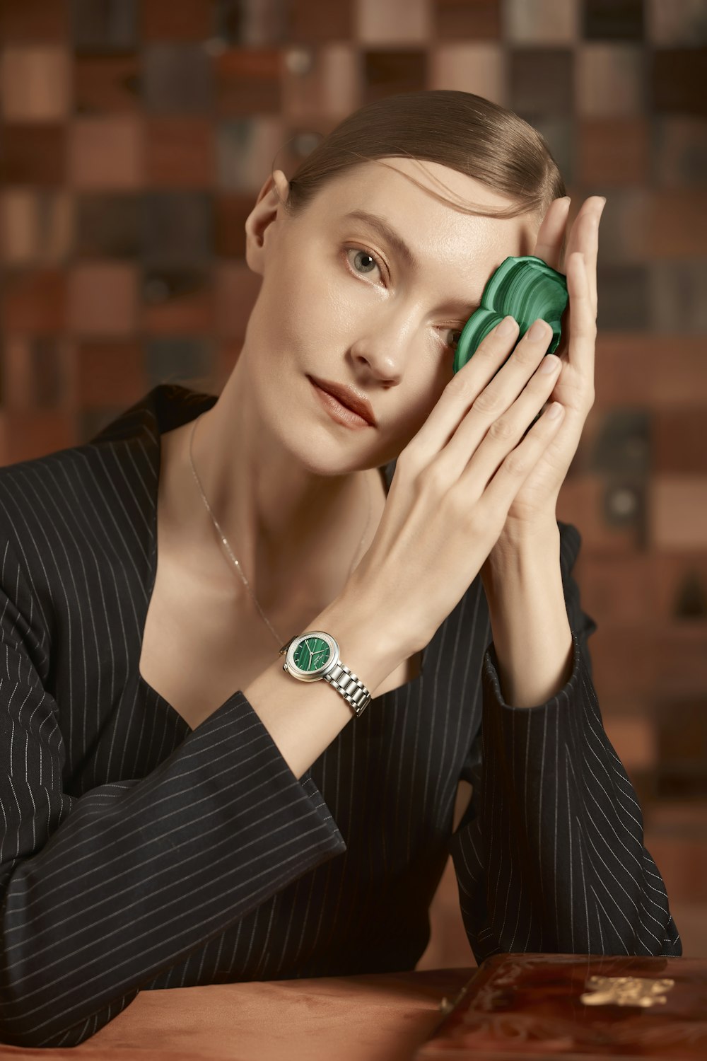 a woman sitting at a table holding a green object