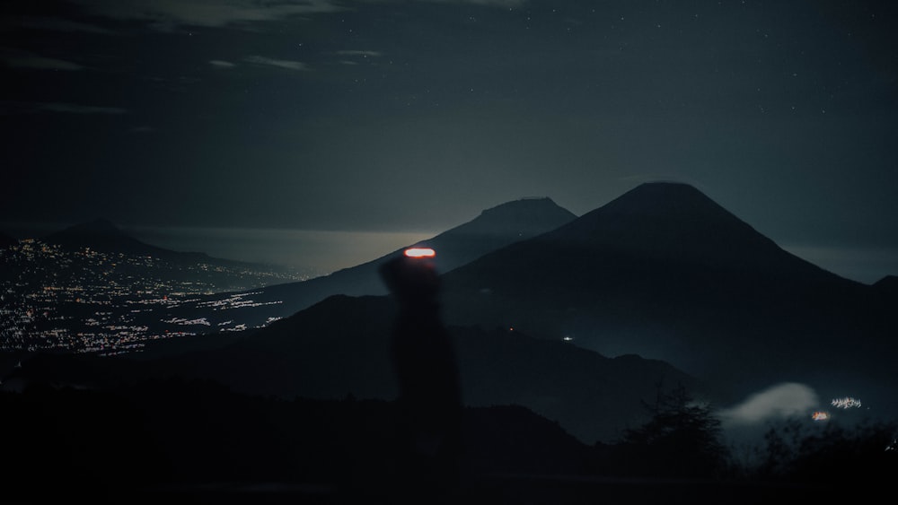 a person standing on a hill at night