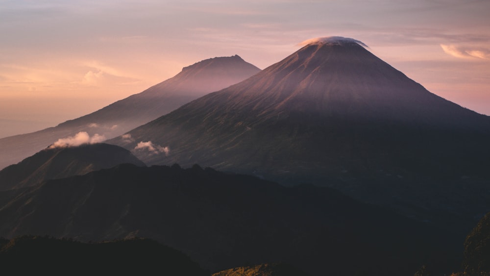 Une très haute montagne avec quelques nuages dans le ciel