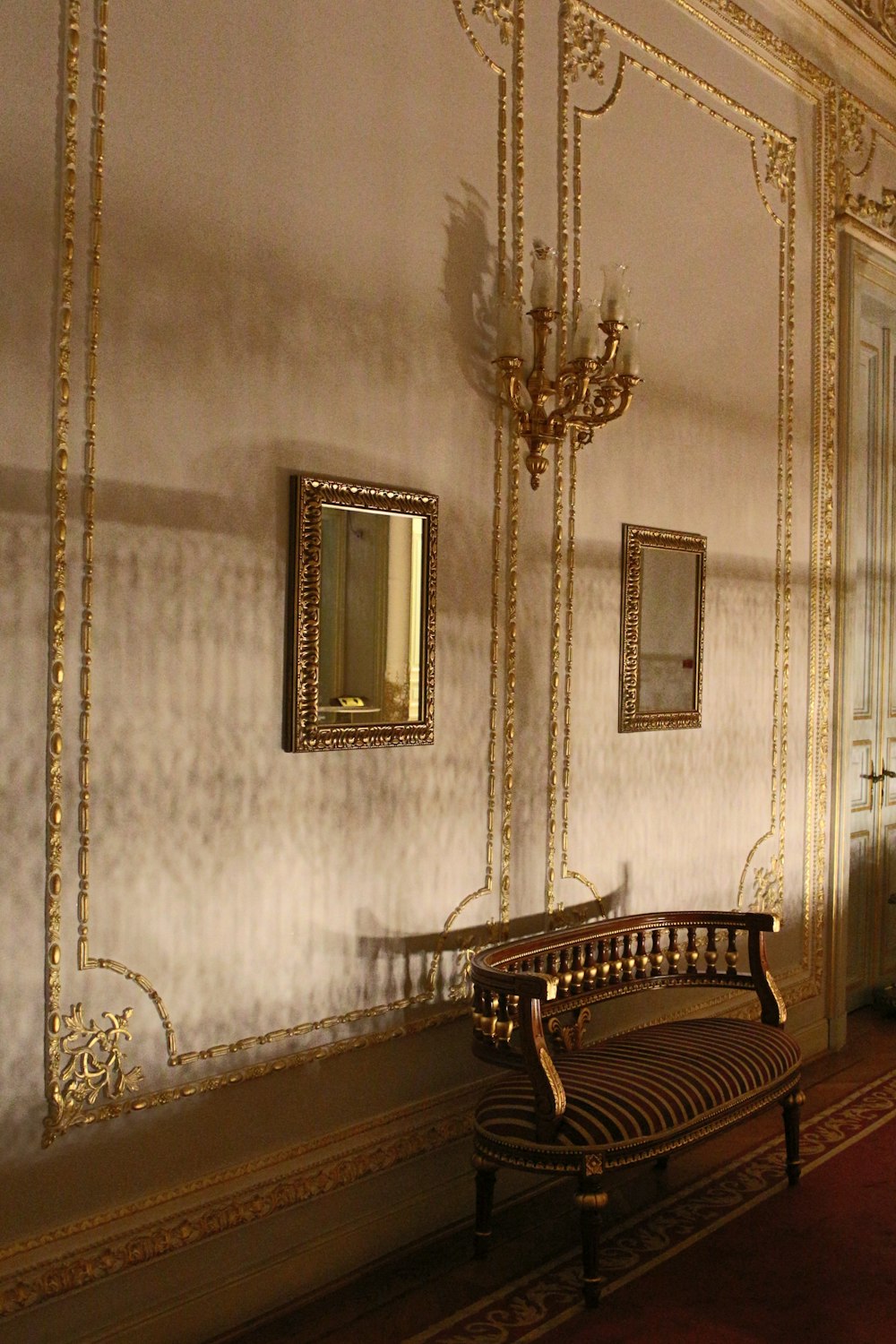 a room with a bench and a chandelier