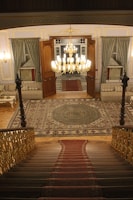 a staircase leading to a large room with a chandelier