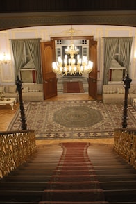 a staircase leading to a large room with a chandelier