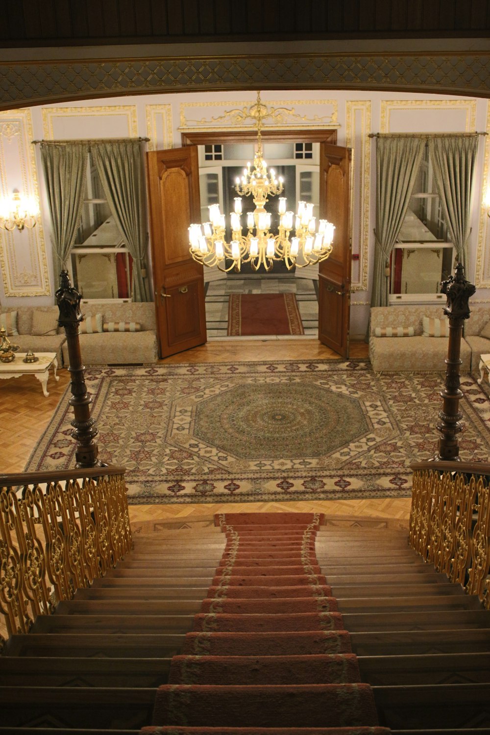 a staircase leading to a large room with a chandelier