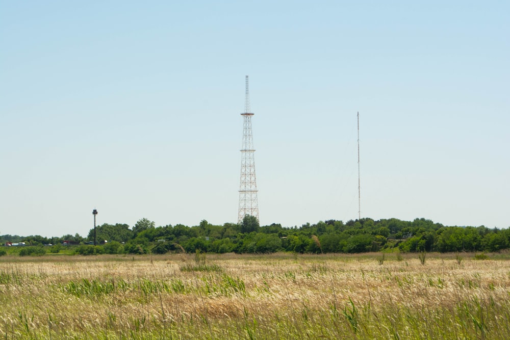 a field with a radio tower in the distance