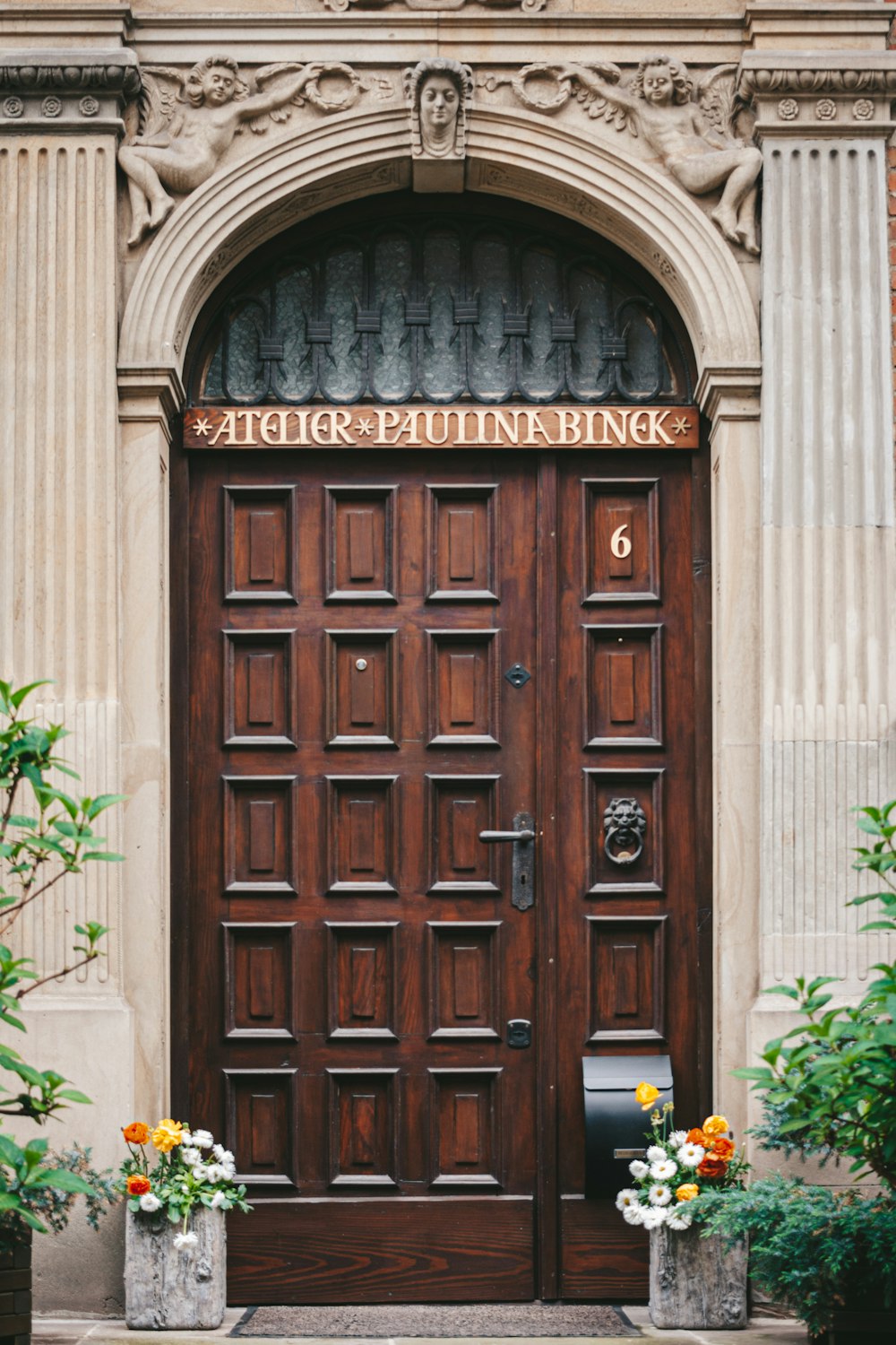 a large wooden door sitting next to a tall building