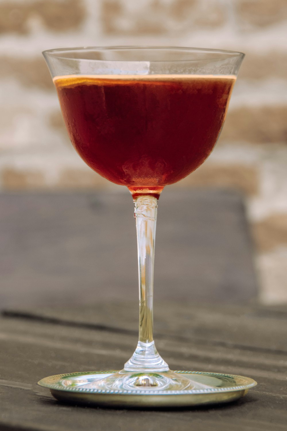 a glass of wine sitting on top of a wooden table