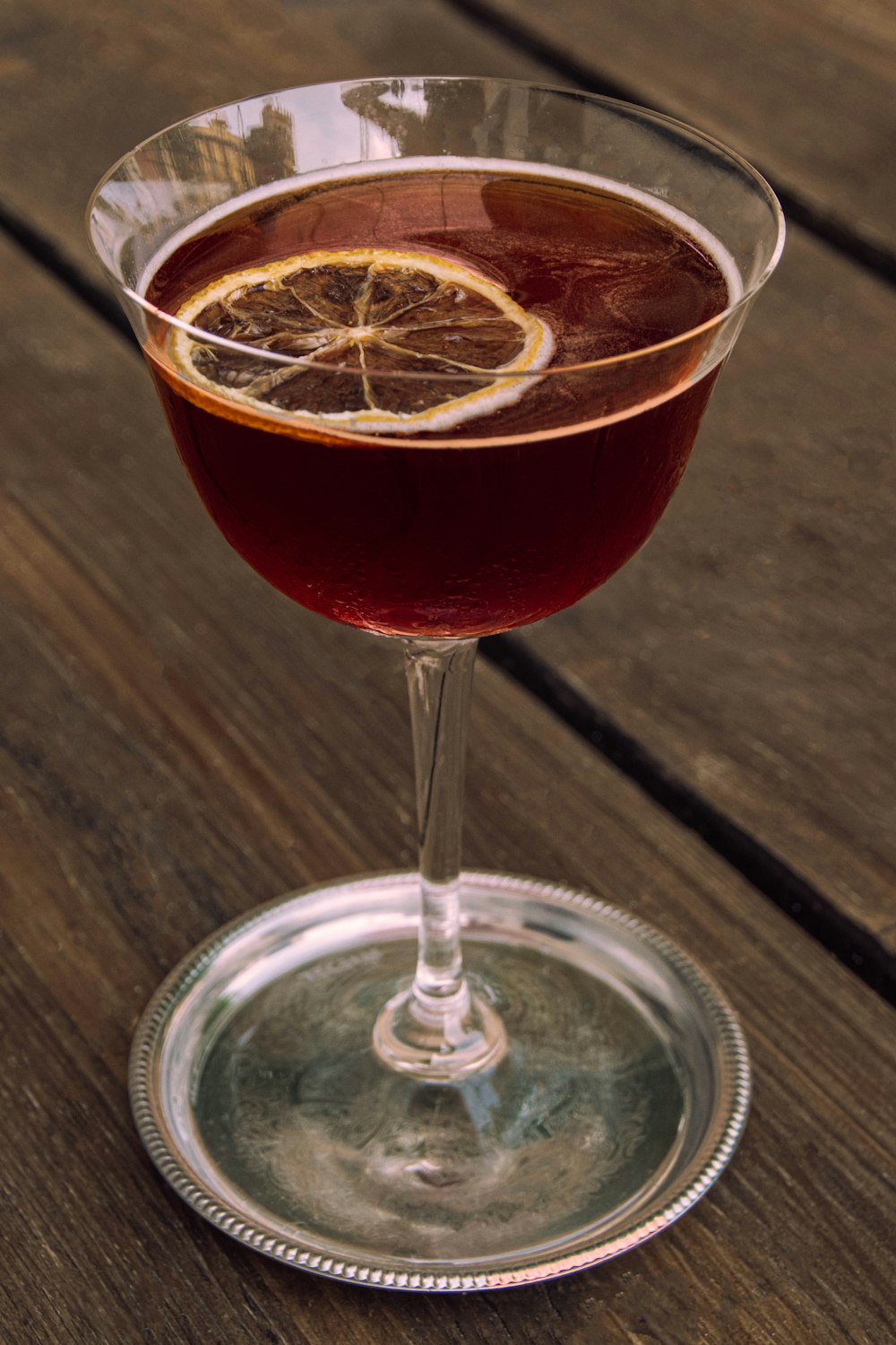 a glass filled with a drink sitting on top of a wooden table