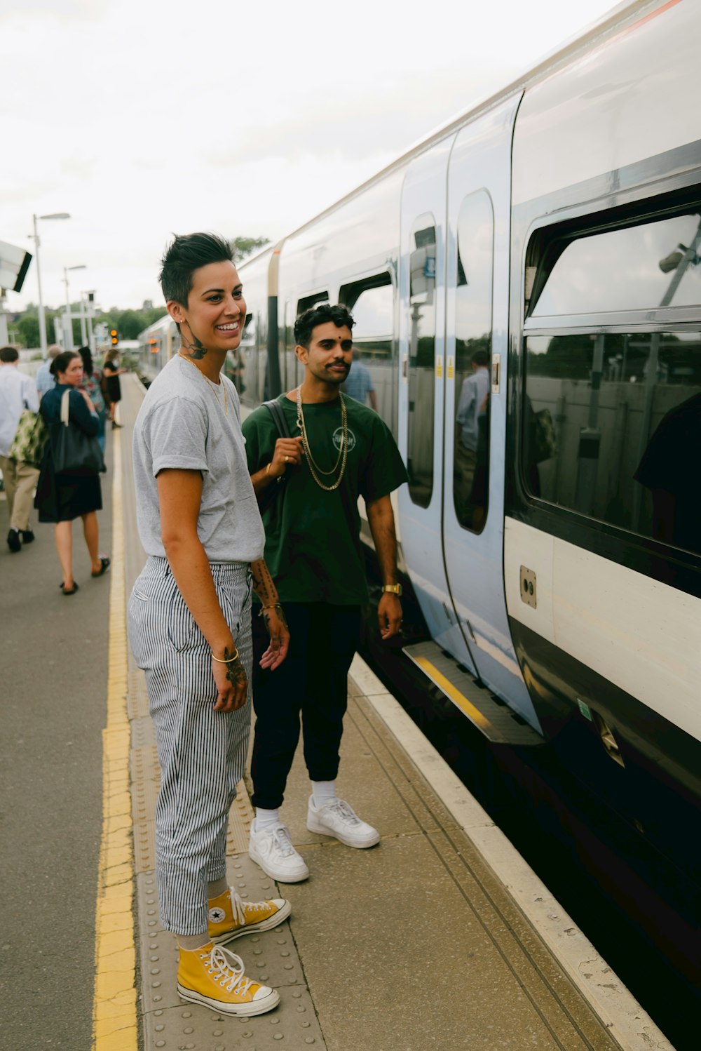 a couple of people standing next to a train