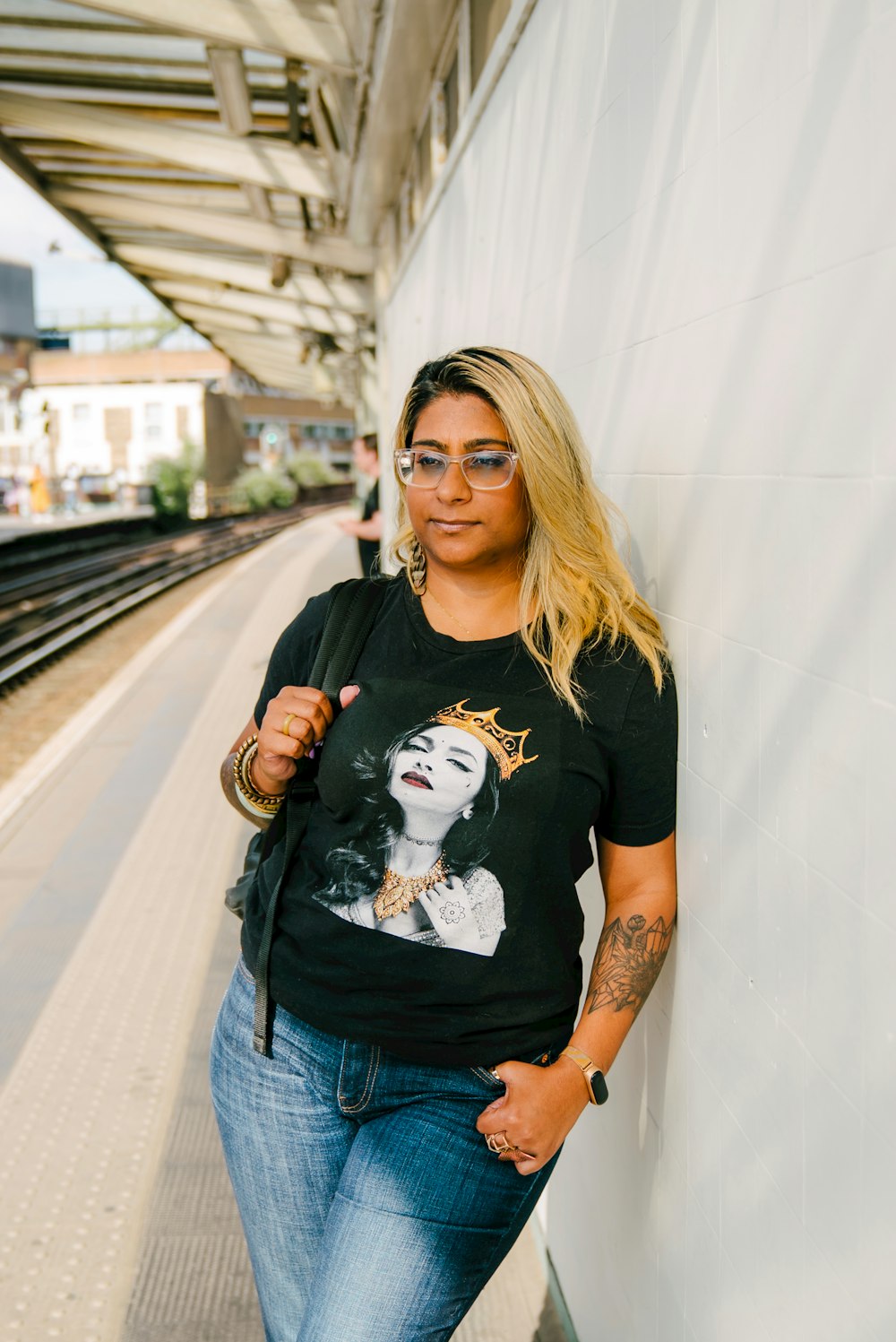 a woman leaning against a wall in a train station