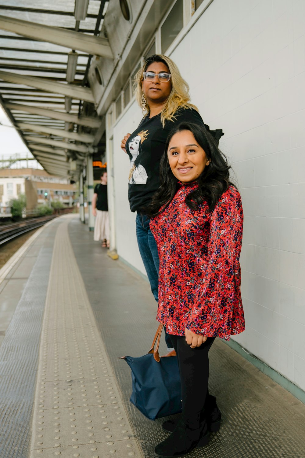 a woman standing next to a man on a train platform