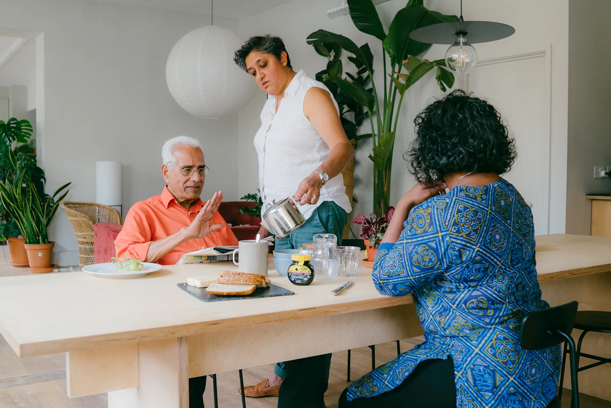 A family of three sharing a meal together at their kitchen table